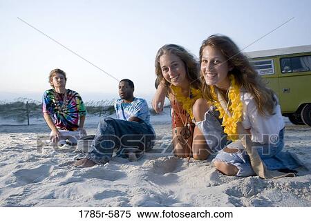 Hippies sitting on sand at beach at dusk View Large Photo Image Stock Photography - Hippies sitting on sand at beach at dusk. Fotosearch