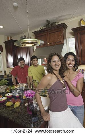 Picture - Indian family in kitchen preparing food. Fotosearch