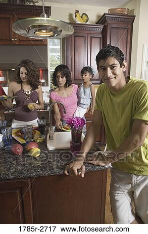 Stock Photo - Indian family in kitchen preparing food. Fotosearch