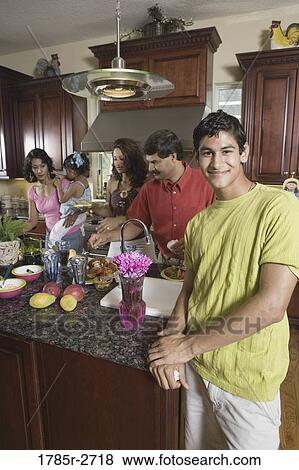 Indian family in kitchen preparing food View Large Photo Image Stock Photo - Indian family in kitchen preparing food. Fotosearch