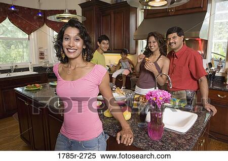 Stock Photography - Indian family in kitchen preparing food. Fotosearch