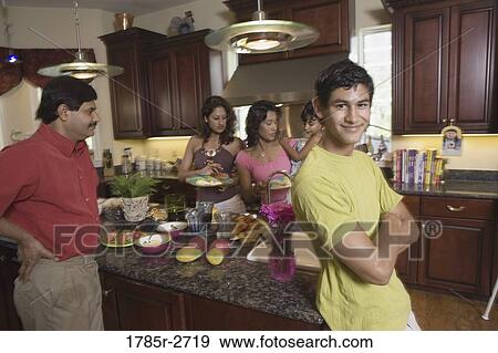 Indian teenage boy with family in kitchen preparing food View Large Photo Image Stock Photo - Indian teenage boy with family in kitchen preparing food. Fotosearch