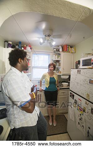 Inter-racial couple talking in kitchen View Large Photo Image Stock Image - Inter-racial couple talking in kitchen. Fotosearch