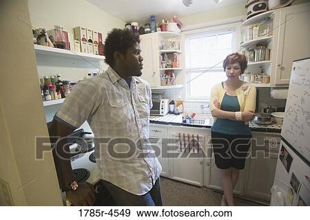 Inter-racial couple talking in kitchen View Large Photo Image Stock Photo - Inter-racial couple talking in kitchen. Fotosearch