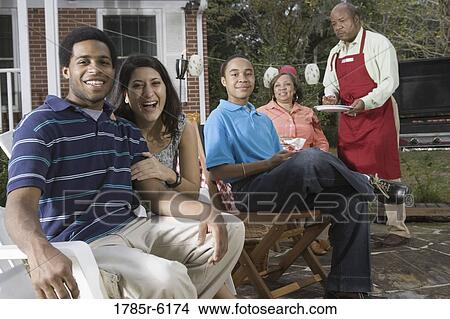 Interracial couple and family enjoying backyard barbeque View Large Photo Image Picture - Interracial couple and family enjoying backyard barbeque. Fotosearch