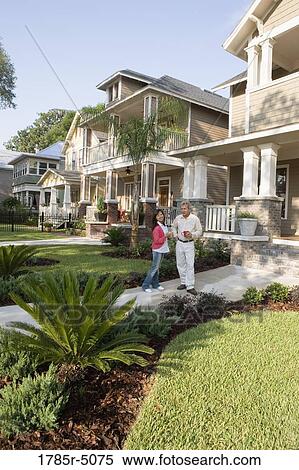 Stock Photography - Interracial couple on front walkway of their house. Fotosearch