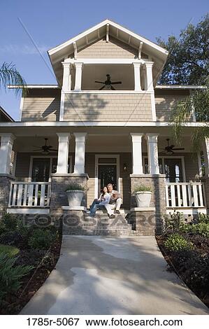 Interracial couple sitting on the front steps of their house View Large Photo Image Stock Photo - Interracial couple sitting on the front steps of their house. Fotosearch