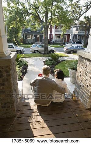 Interracial couple sitting on the front steps of their house View Large Photo Image Stock Photo - Interracial couple sitting on the front steps of their house. Fotosearch