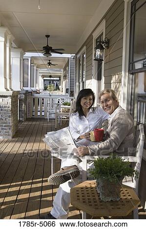 Stock Photograph - Interracial couple sitting on the front porch. Fotosearch
