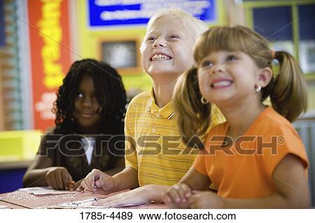 Kids posing and smiling together in a colorful classroom View Large Photo Image Stock Photo - Kids posing and smiling together in a colorful classroom. Fotosearch