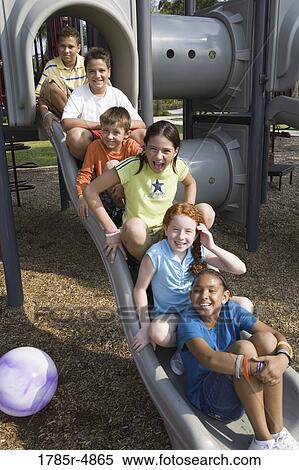 Laughing children sitting on a slide at a playground View Large Photo Image Stock Photography - Laughing children sitting on a slide at a playground. Fotosearch