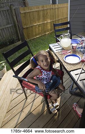 Little girl on backyard patio ready for 4th of July celebration View Large Photo Image Picture - Little girl on backyard patio ready for 4th of July celebration. Fotosearch