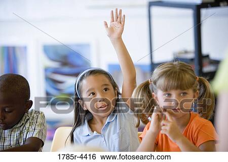 Stock Photograph - Little girl raising her hand in class. Fotosearch