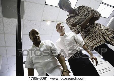 Long angle portrait of three business people in an office View Large Photo Image Stock Image - Long angle portrait of three business people in an office. Fotosearch