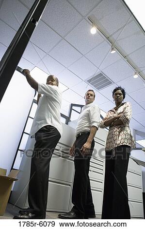 Long angle portrait of three business people in an office View Large Photo Image Stock Photo - Long angle portrait of three business people in an office. Fotosearch