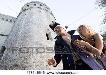 Low angle view of a navy officer and a princess sneaking around a castle wall and turrets View Large Photo Image Stock Photograph - Low angle view of a navy officer and a princess sneaking around a castle wall and turrets. Fotosearch