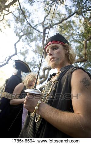 Picture - Low-angle view of a pirate holding a sword. Fotosearch