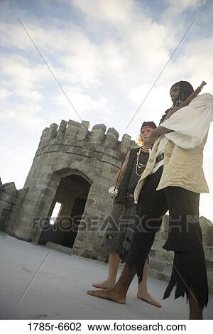 Low angle view of armed pirates with castle parapets and turrets in the background View Large Photo Image Stock Image - Low angle view of armed pirates with castle parapets and turrets in the background. Fotosearch
