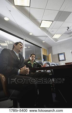 Low angle view of business man and woman meeting in a formal conference room View Large Photo Image Stock Image - Low angle view of business man and woman meeting in a formal conference room. Fotosearch