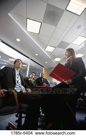 Low angle view of business men and women at a presentation in a formal conference room View Large Photo Image Picture - Low angle view of business men and women at a presentation in a formal conference room. Fotosearch