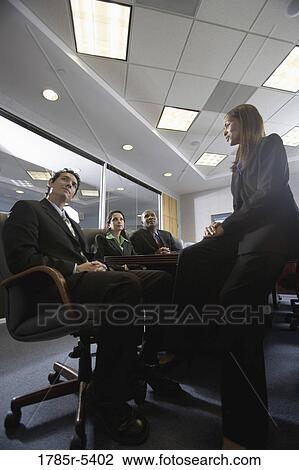Low angle view of business men and women meeting in a formal conference room View Large Photo Image Stock Image - Low angle view of business men and women meeting in a formal conference room. Fotosearch