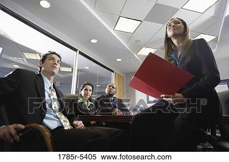 Low angle view of business men and women at a presentation in a formal conference room View Large Photo Image Stock Photography - Low angle view of business men and women at a presentation in a formal conference room. Fotosearch