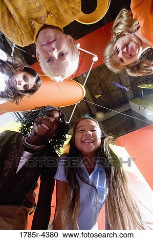 Low angle view of children in a circle looking downwards View Large Photo Image Stock Image - Low angle view of children in a circle looking downwards. Fotosearch