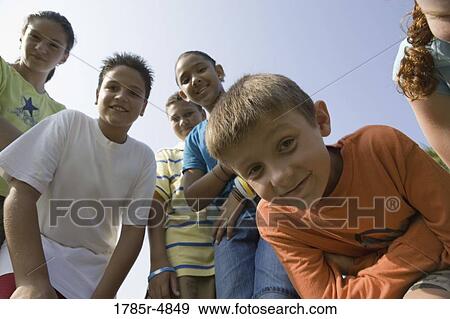 Low angle view of children with folded arms standing together at a playground View Large Photo Image Stock Photo - Low angle view of children with folded arms standing together at a playground. Fotosearch