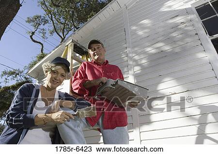 Low angle view of mature couple with ladder and painting tools preparing to paint outside of house View Large Photo Image Stock Image - Low angle view of mature couple with ladder and painting tools preparing to paint outside of house. Fotosearch