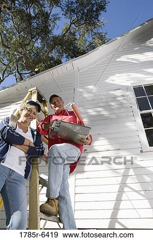 Low angle view of mature couple with ladder and painting tools preparing to paint outside of house View Large Photo Image Stock Photo - Low angle view of mature couple with ladder and painting tools preparing to paint outside of house. Fotosearch