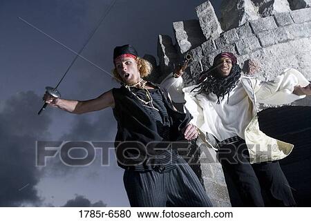 Low angle view of pirates brandishing a sword and a gun View Large Photo Image Stock Image - Low angle view of pirates brandishing a sword and a gun. Fotosearch