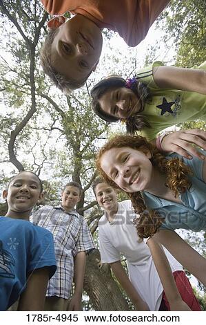 Low angle view of three boys and three girls standing in a circle at a park View Large Photo Image Stock Photography - Low angle view of three boys and three girls standing in a circle at a park. Fotosearch