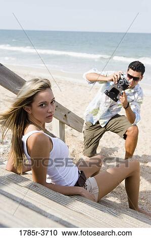 Man photographing a woman at the beach View Large Photo Image Stock Image - Man photographing a woman at the beach. Fotosearch