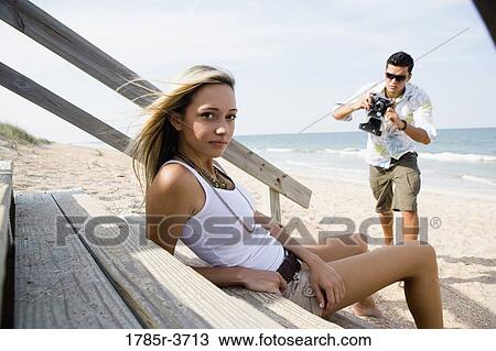 Man photographing a woman at the beach View Large Photo Image Stock Image - Man photographing a woman at the beach. Fotosearch