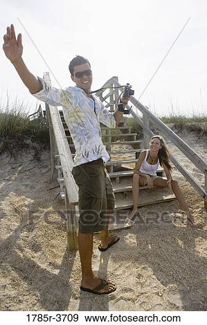 Man photographing a woman at the beach View Large Photo Image Stock Photo - Man photographing a woman at the beach. Fotosearch