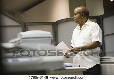 Mature businessman standing in an office cubicle View Large Photo Image Stock Photo - Mature businessman standing in an office cubicle. Fotosearch