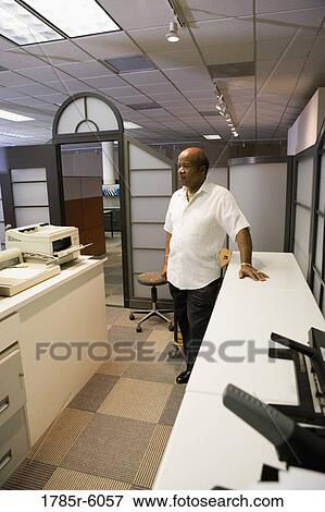Mature businessman standing in office View Large Photo Image Stock Photo - Mature businessman standing in office. Fotosearch