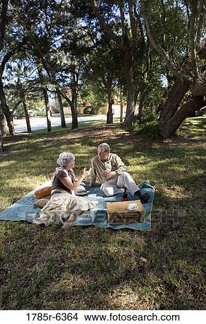 Mature couple having a picnic enjoying wine View Large Photo Image Picture - Mature couple having a picnic enjoying wine. Fotosearch