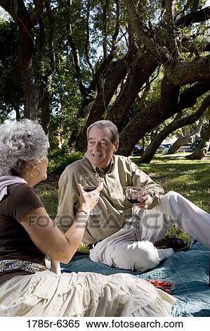 Stock Photography - Mature couple having a picnic enjoying wine. Fotosearch