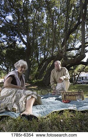 Mature couple having a picnic in a park View Large Photo Image Picture - Mature couple having a picnic in a park. Fotosearch