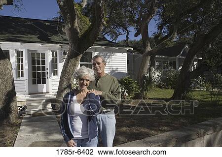 Mature couple in front of house surrounded by tall oak trees View Large Photo Image Stock Image - Mature couple in front of house surrounded by tall oak trees. Fotosearch