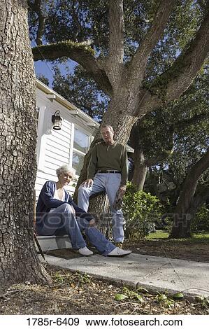 Mature couple on doorstep of home under large oak trees View Large Photo Image Stock Photo - Mature couple on doorstep of home under large oak trees. Fotosearch