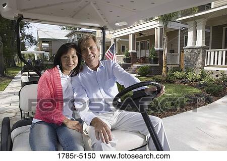 Mature couple riding golf cart through the neighborhood View Large Photo Image Stock Image - Mature couple riding golf cart through the neighborhood. Fotosearch