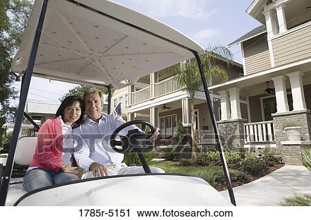 Mature couple riding golf cart through the neighborhood View Large Photo Image Stock Image - Mature couple riding golf cart through the neighborhood. Fotosearch
