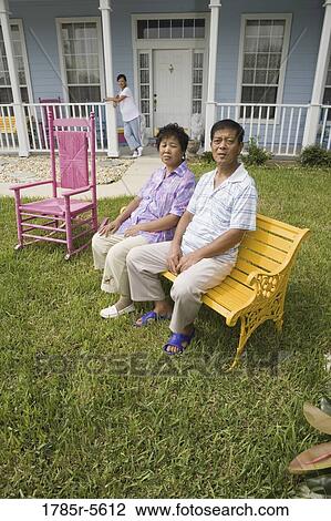 Mature couple sitting in front lawn of house, pregnant daughter on porch View Large Photo Image Stock Image - Mature couple sitting in front lawn of house, pregnant daughter on porch. Fotosearch