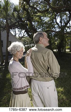 Mature couple standing together under oak trees View Large Photo Image Stock Photo - Mature couple standing together under oak trees. Fotosearch