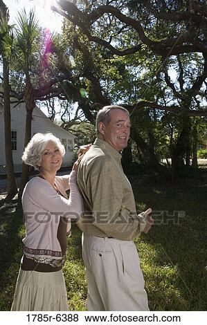 Mature couple standing together under oak trees View Large Photo Image Stock Photo - Mature couple standing together under oak trees. Fotosearch