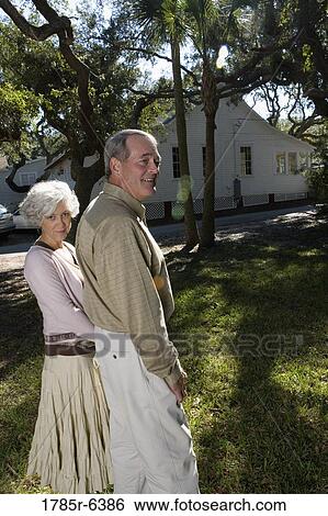 Mature couple standing together under oak trees View Large Photo Image Stock Photograph - Mature couple standing together under oak trees. Fotosearch