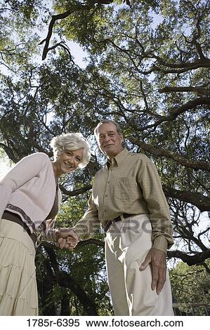 Mature couple standing together under oak trees View Large Photo Image Stock Photography - Mature couple standing together under oak trees. Fotosearch