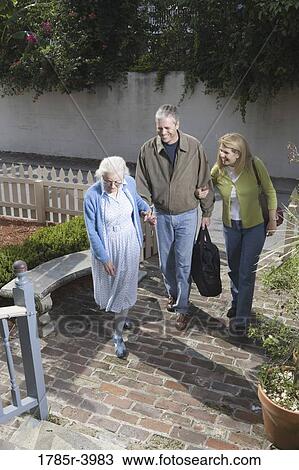 Mature couple walking with senior woman towards front of house View Large Photo Image Stock Image - Mature couple walking with senior woman towards front of house. Fotosearch
